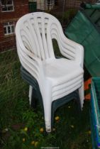 Four white plastic chairs and three green plastic chairs.