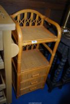 A bamboo bedside table with three drawers.