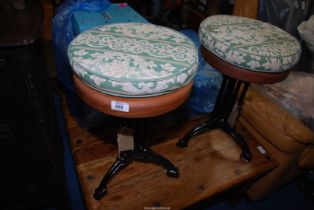 A pair of cast iron based circular Mahogany seated Stools and cushions.