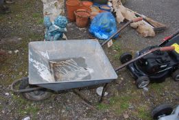 A galvanized wheelbarrow with solid tyre.