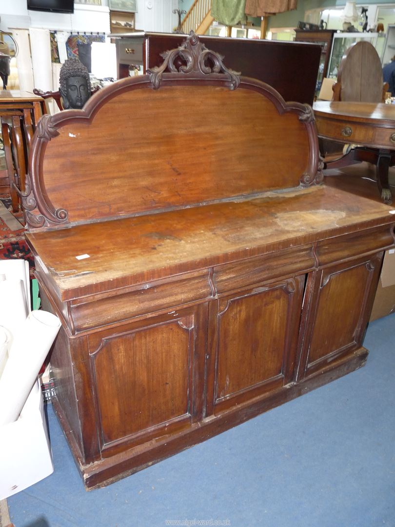 A Victorian Mahogany Sideboard having three frieze drawers and a triple doored cupboard below,