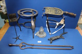 A pierced brass work and wrought iron trivet with hooks for attachment to a fire front,