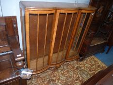 A Walnut finished china Display Cabinet standing on brief cabriole legs.