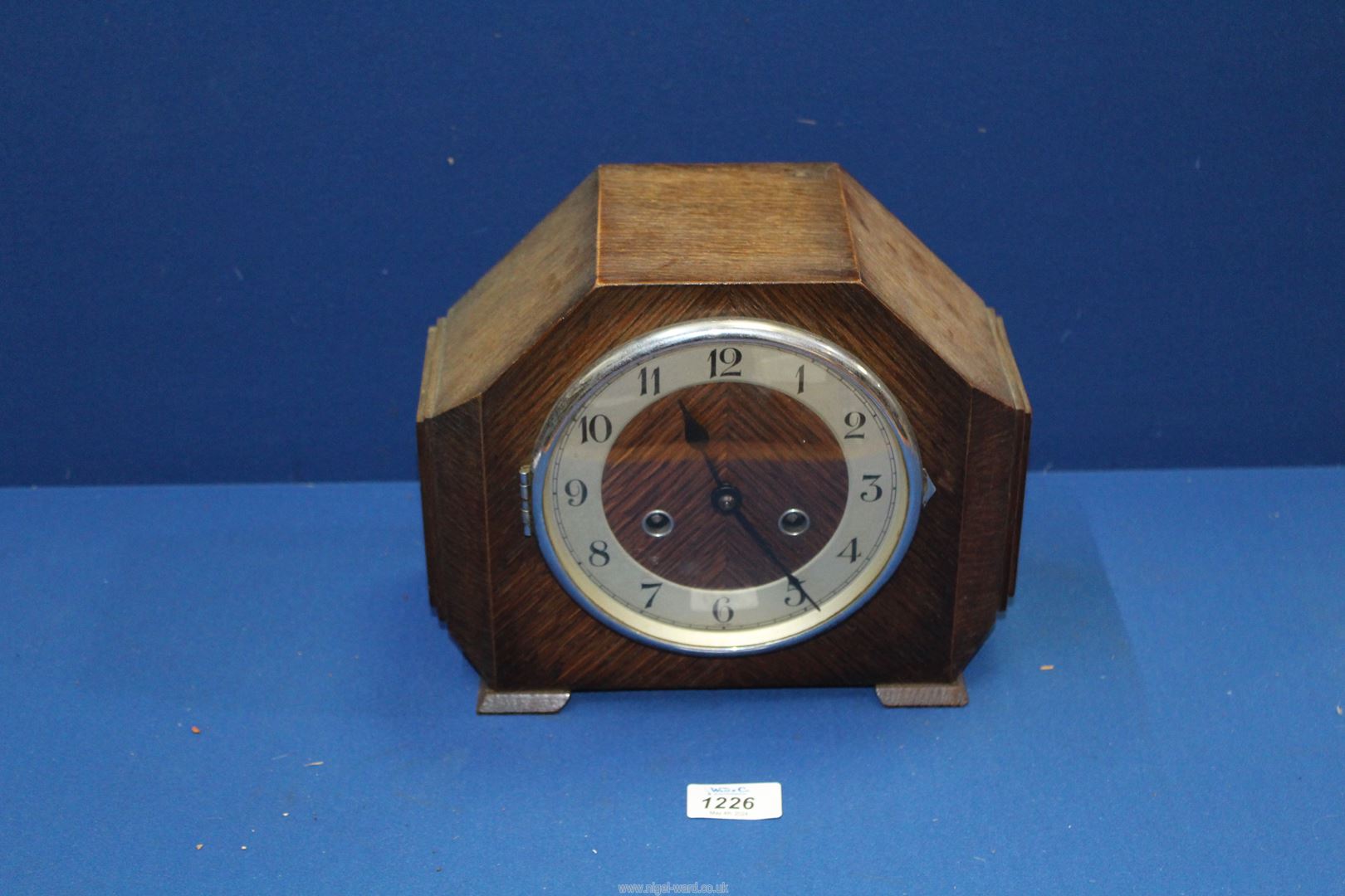 An oak two train Art Deco style Mantle Clock having Arabic numerals with pendulum and key,