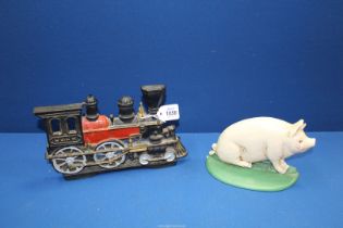 A cast metal white pig doorstop, 7" long and a large cast metal steam train doorstop, 10" long.