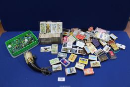 A quantity of tea cards, matchboxes, marbles and souvenir horn.