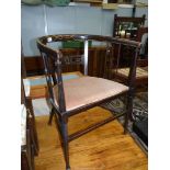 An arts and crafts type bow-back Boxwood strung Mahogany framed Elbow Chair having fretworked and