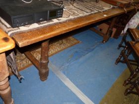 A large Oak Dining Table standing on substantial turned legs united by a "H" stretcher,