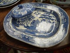 A blue and white Willow pattern meat plate together with a Willow pattern sauce tureen.