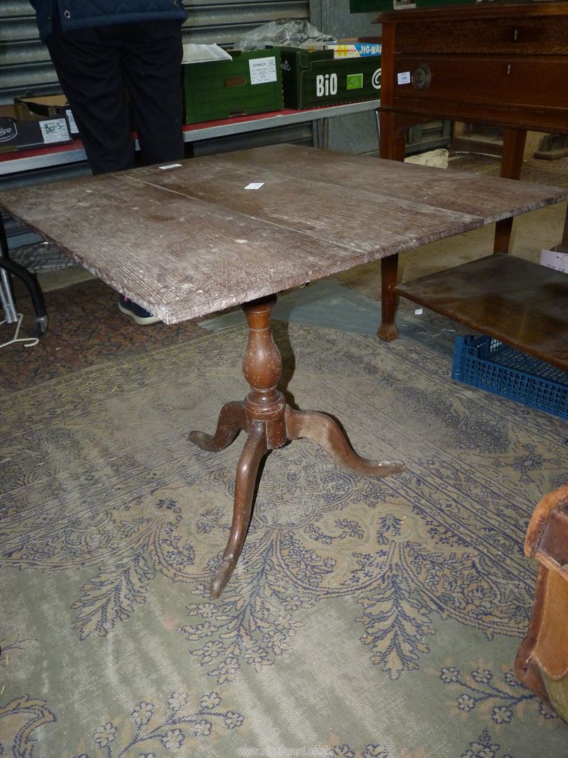 An Oak snap-top Occasional Table, the square top raised on a turned pillar with three splay feet,