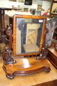 A circa 1900 Mahogany swing Mirror having scroll feature side supports and a shaped base,