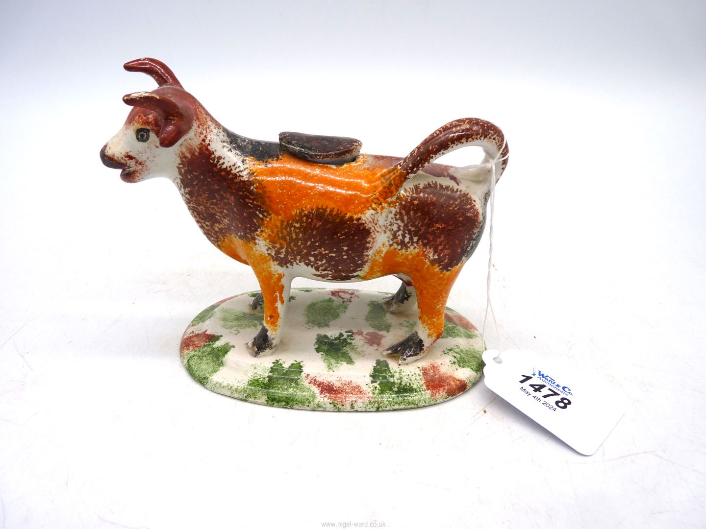 A 19th century Staffordshire cow creamer having over glazed sponged colour, 6 1/2" x 4 3/4" tall.