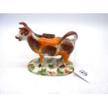 A 19th century Staffordshire cow creamer having over glazed sponged colour, 6 1/2" x 4 3/4" tall.