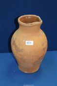 A large terracotta jug (handle missing), 13" tall.