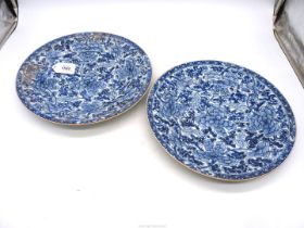 A pair of blue and white floral chargers decorated with peonies and foliage and decoration to the