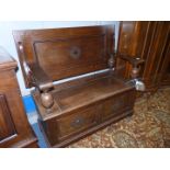 An Oak Monks Seat having a locker base, the arms supported on bulbous turned supports,