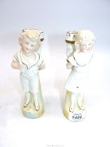 A pair of spill Vases in the form of a young girl and boy with baskets on their backs (some