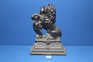 A heavy cast metal Doorstop in the form of a lion on its haunches, 15 1/2" tall.