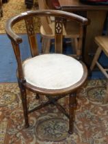 An arts and crafts circular seated bow back Elbow Chair standing on turned legs with turned cross