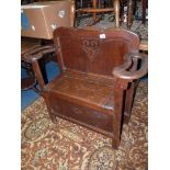 An Oak Hall Seat having a locker base, the arms with apertures for sticks,