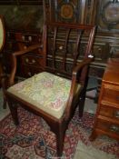 An elegant Georgian Mahogany open armed carver/elbow Chair having stylised floral bosses to the