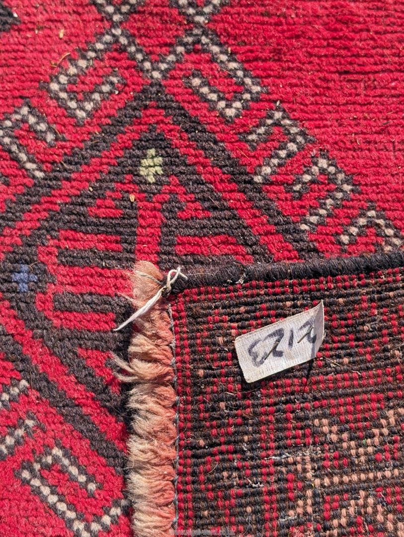 A large border patterned rug on a red ground having black central diamonds, - Image 3 of 4