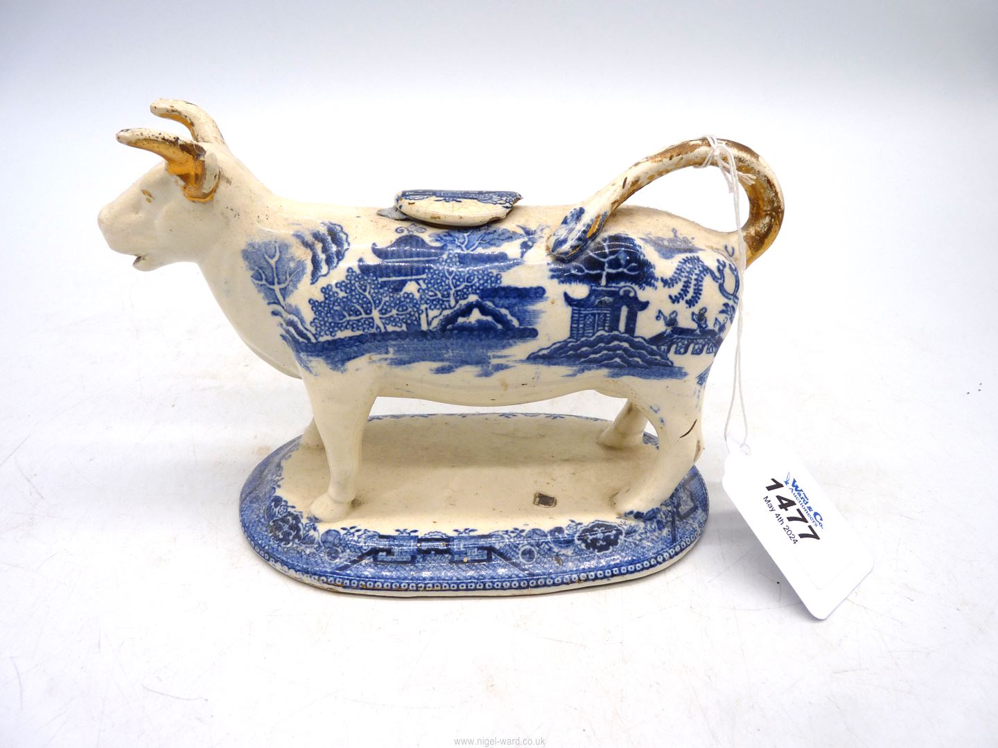 A blue and white willow pattern transfer printed cow creamer, circa 1830,