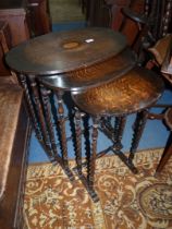 A nest of three oval Oak occasional Tables having twist legs and turned stretchers,