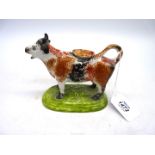 A mid 19th century Staffordshire cow creamer in Yorkshire sponged colours with over glaze (firing