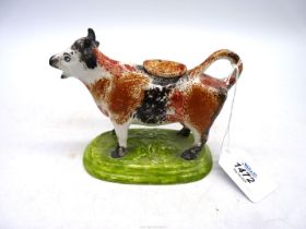 A mid 19th century Staffordshire cow creamer in Yorkshire sponged colours with over glaze (firing