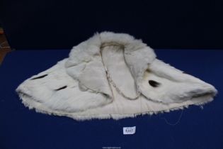 A short ermine cape having high fur lined collar, front hook fastening (in checked zip up bag).