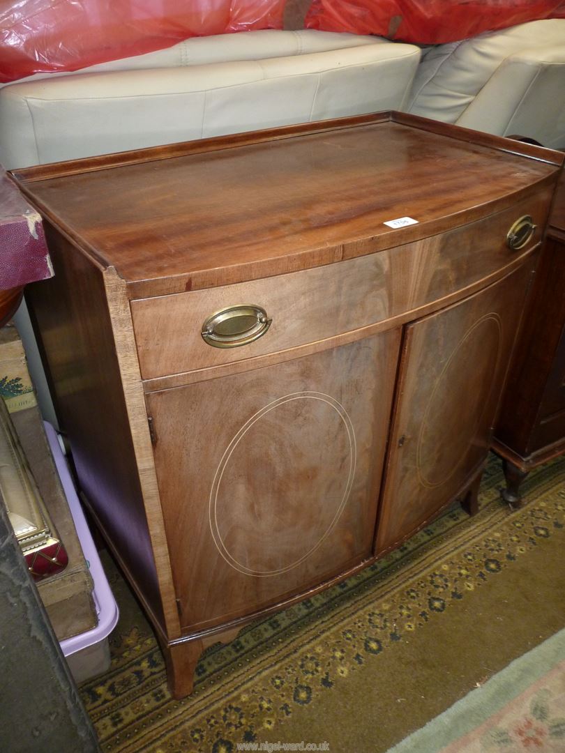 A Mahogany bow fronted Cabinet having a pair of opposing doors with oval Boxwood stringing,