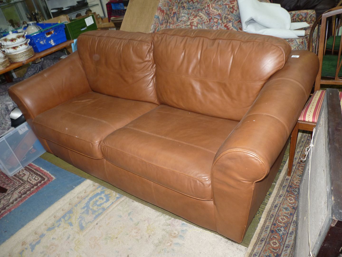 A two/three seater brown upholstered Settee.