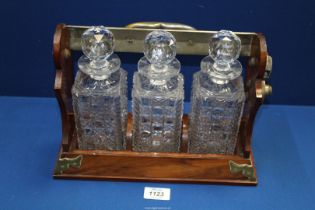 A Betjeman's Tantalus with three cut glass decanters (one rim chipped).