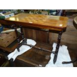A Walnut and other woods Occasional Table standing on a pair of turned supports to either side