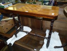 A Walnut and other woods Occasional Table standing on a pair of turned supports to either side
