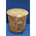 An Eastern style table with eight hinged fretwork sides and round curved top, 18" tall,