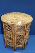 An Eastern style table with eight hinged fretwork sides and round curved top, 18" tall,