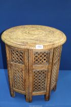 An Eastern style table with eight hinged fretwork sides and round curved top, 18" tall,