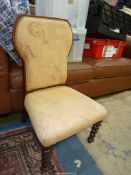 A Mahogany framed beige upholstered Chair standing on mirrored twist front legs.