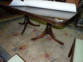 A Mahogany dining Table having double pedestals with swept reeded legs terminating in brass capped