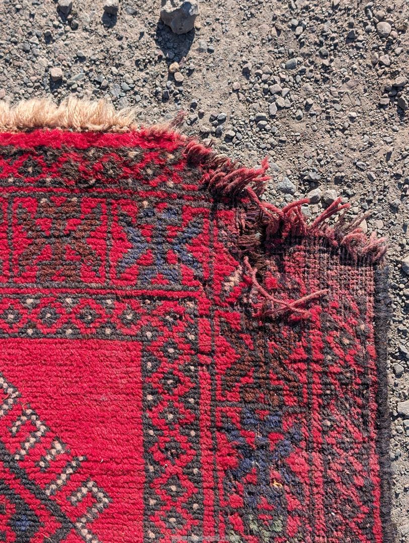 A large border patterned rug on a red ground having black central diamonds, - Image 4 of 4