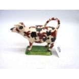 A 19th century cow creamer having over glazed sponge decoration, 6 3/4" x 5 1/4" tall.