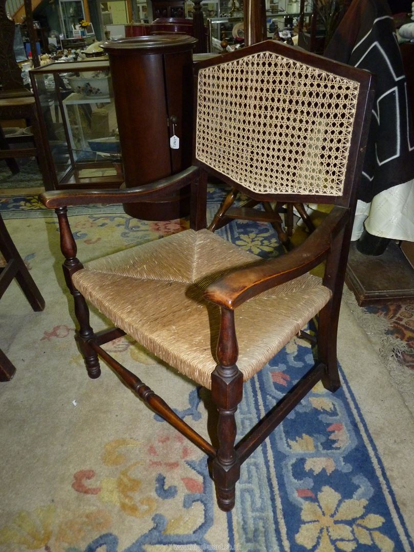 A Mahogany framed low open armed Elbow Chair standing on turned front legs and having a woven