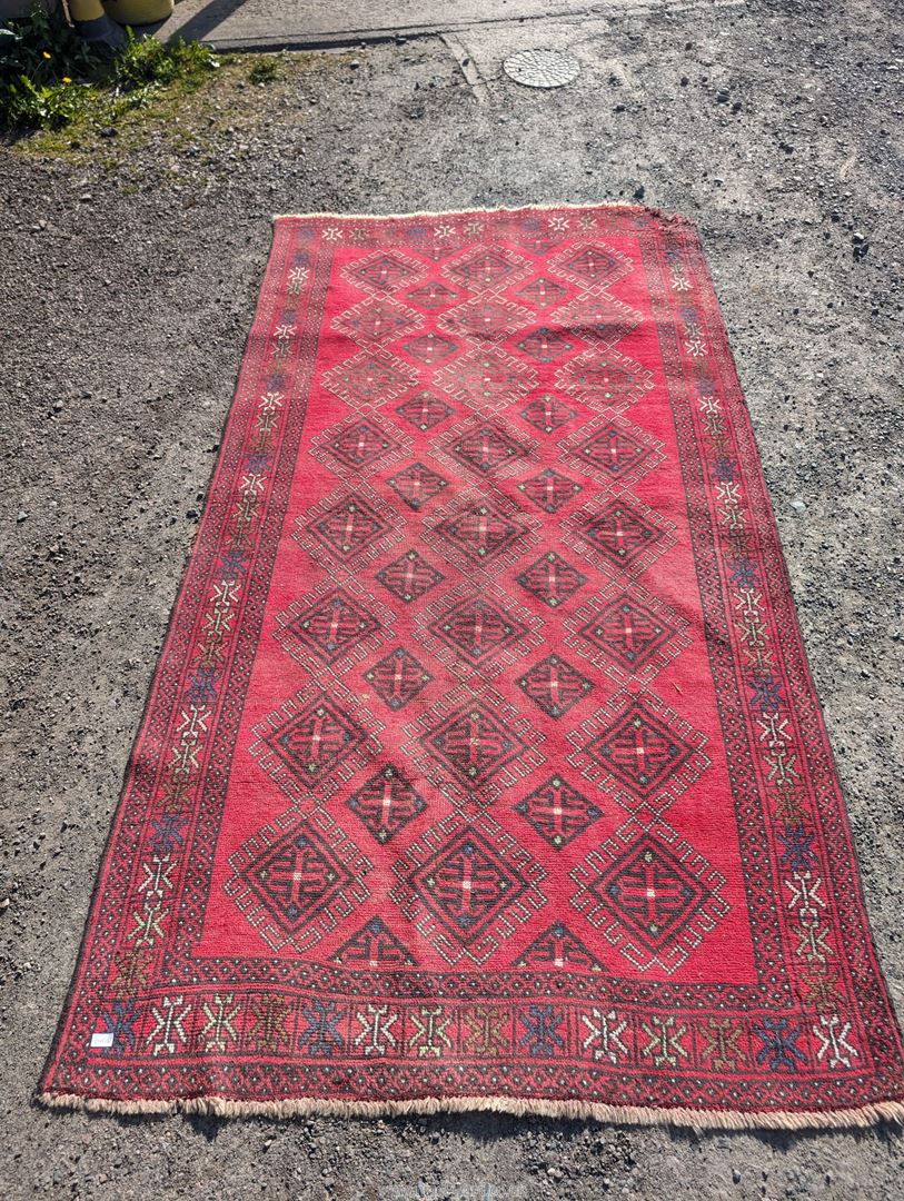 A large border patterned rug on a red ground having black central diamonds, - Image 2 of 4