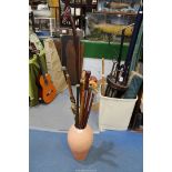 A quantity of walking sticks, one with brass duck head etc., in a clay pot/stick stand.