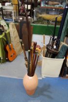 A quantity of walking sticks, one with brass duck head etc., in a clay pot/stick stand.