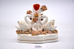 A Staffordshire spill vase, circa 1860, in the form of a swan group having bocage decoration,
