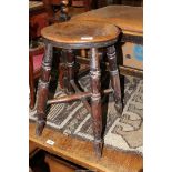 A circular rustic Elm seated Stool standing on four legs united by a cross-stretcher,