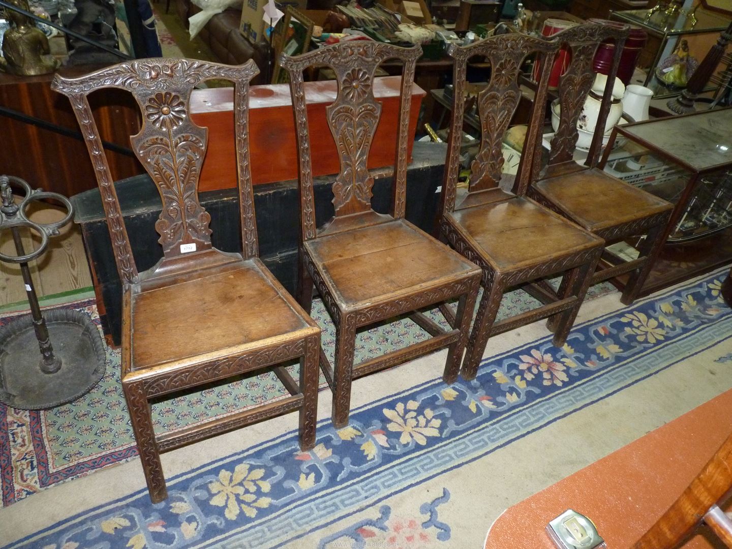 A set of four carved early Oak Dining Chairs having solid seats,